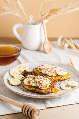 Ready to eat sandwiches with honey, banana and chocolate on a plate on the table. Homemade vegetarian snack. Vertical view