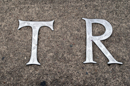Steel Letters Inset into Concrete Pavement beside river-'T and R' in Close Up