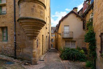 Fototapeta na wymiar The narrow street of a beautiful french yellow stone medieval town of Perigord