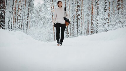 a tourist walks along a forest path in a winter forest after a snowfall