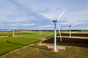 Aerial shot of wind farm turbines in farmland, UK