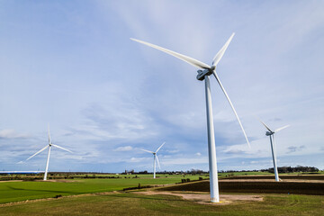 Aerial shot of wind farm turbines with blue cloudy sky, UK