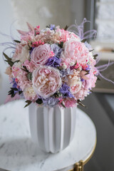Beautiful preserved flower bouquet in ceramic vase on white table. Home flowers decor.