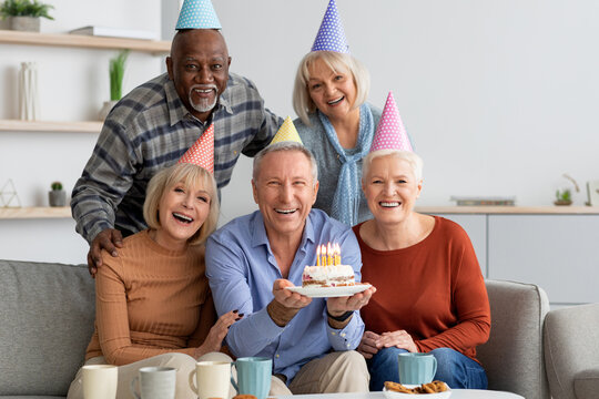 International group of elderly people having birthday party at home
