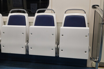 Three empty raised seats in a subway car