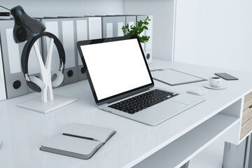 Close up of creative designer desktop with folders bookcase, empty laptop screen, coffee cup,...