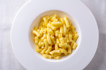 spaghetti on a white plate and a white table
