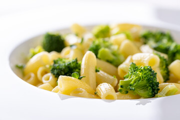 pasta with broccoli on a white plate and white ceramic background.