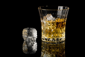 whiskey and ice with reflection on a black background