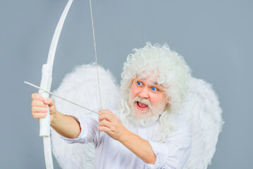Valentines Day. Funny cupid aiming with bow and arrow. Angel with wings and white wig. Saint...
