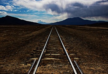 vías del ferrocarril  en el desierto con montaña