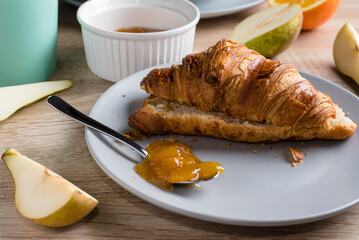 Healthy breakfast. Croissant, donut, coffee, jam, fruits: oranges and pears.