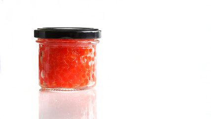 Fototapeta na wymiar Glass jar with red salmon caviar, closed with a black metal lid. White background. Copy space for an inscription