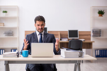 Young male employee sitting at workplace