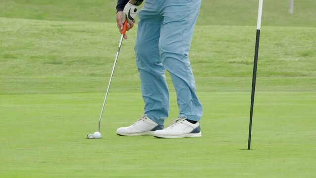The luckiest shot in golf . The golf ball rolls into the hole. The joy and gesture of victory