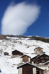 Eclaircie en hiver avec des chalets d'alpage en montagne