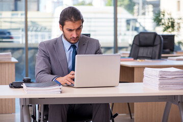 Young male employee in wheel-chair working in the office