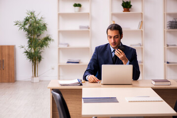 Young male employer sitting in the office