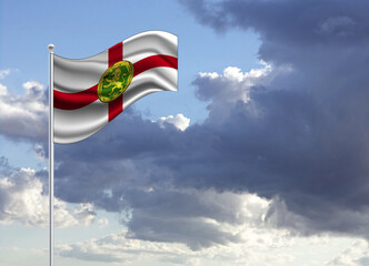 Flag of the Alderney on a stick, dark clouds in the background