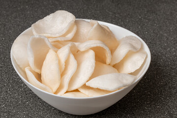 Cooked rice chips in bowl - Grey background