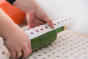 Frau packt Flasche in Geschenkpapier