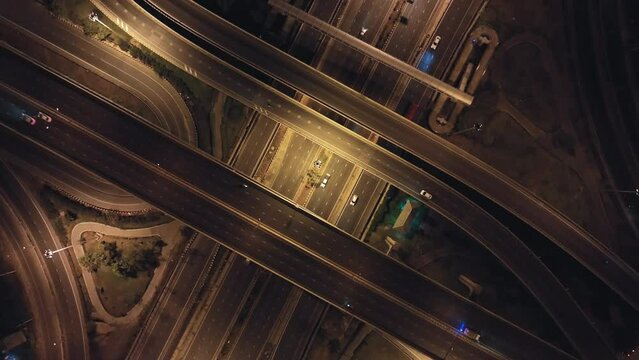Car traffic transportation on highway road intersection in Bangkok city, Thailand at night. Public transport, commuter lifestyle, Asian city life concept. Drone aerial top view