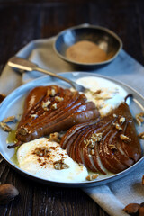 Caramelized pear with nuts and buttercream on a plate. Healthy dessert.