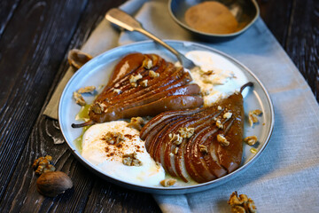 Caramelized pear with nuts and buttercream on a plate. Healthy dessert.