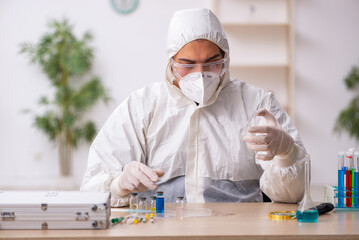 Young male chemist working at the lab during pandemic