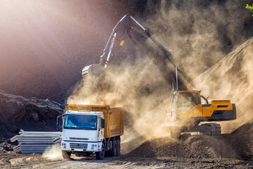 Excavator and truck for construction site. Excavation is the process of moving earth, rock or other...