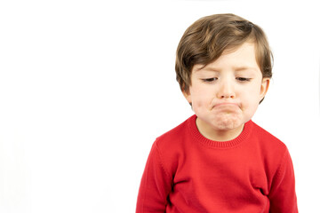 A boy in a red sweater is bored and tired.