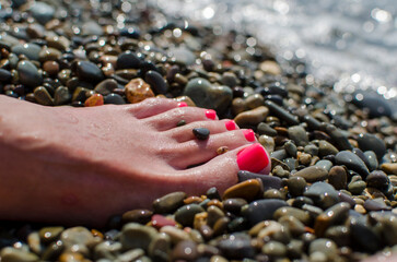 wet foot of a girl on a rocky beach