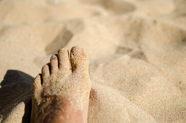 wet feet of a man on a sandy beach