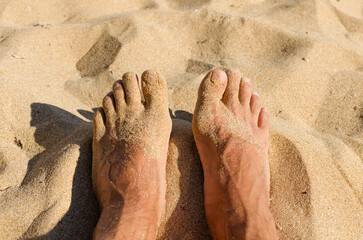 wet feet of a man on a sandy beach