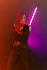 red-haired girl dressed as in Star Wars with a light sabre