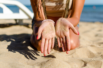hands in the sand of a young girl on the beach