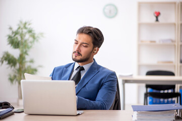 Deaf male employee using hearing aid at workplace