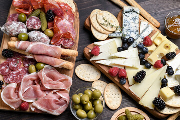 Italian food antipasti prosciutto ham, salami, olives and grissini bread sticks. cheese on a board...