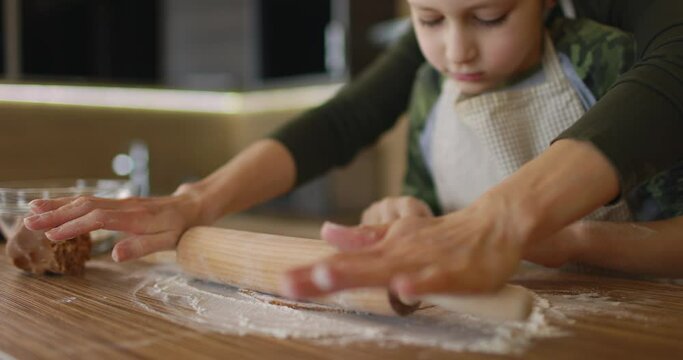 Happy mother and son cooking cookies together in the kitchen. Family day, Cooking, Mom and son concept. Slow motion