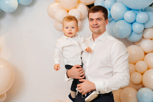 happy dad and son in front of the photo zone with balloons