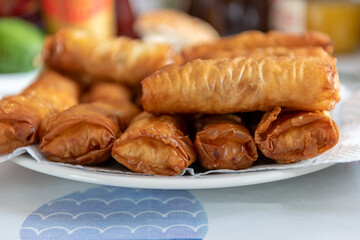 A full plate of fried golden, crispy spring rolls.