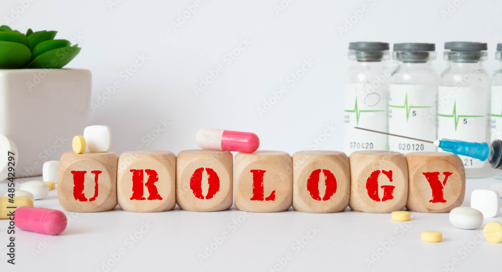 Poster word urology. urology text on wooden blocks. in front of a row of cubes are ampoules