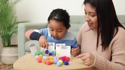 Asian kid playing didactic game with his mom at home - Montessori education concept