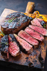Traditional barbecue dry aged wagyu rib-eye beef steaks served with paprika and zucchini as...