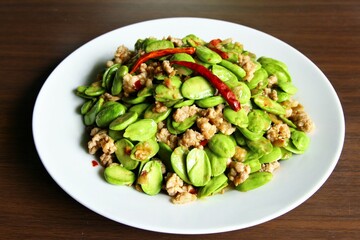 A plate of stir fried parkia speciosa or bitter bean with mince pork red chili on top typical food in Thailand. stock photo  