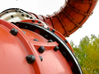 Deurstickers Selective focus on the articulation fragment of the elements of a large red curved pipe for riding on the children's playground. © Nekrasov