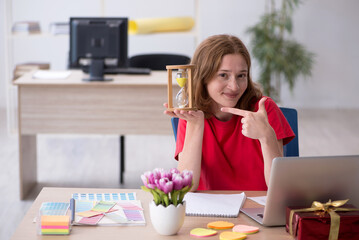 Young female designer in time management concept