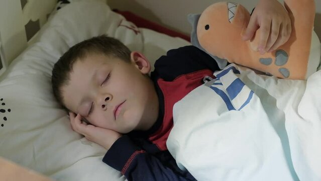 a five-year-old boy sleeps in his crib