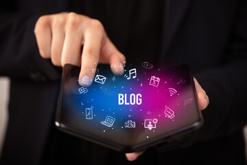 Businessman holding a foldable smartphone, social media concept