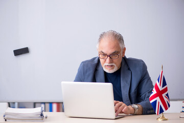 Old male english language teacher in the classroom